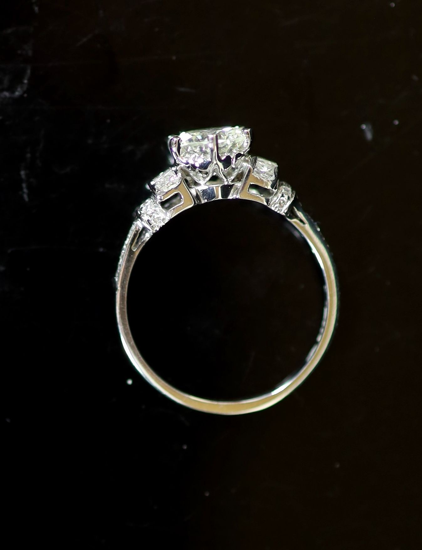 A modern platinum and single stone diamond ring centre with fancy and round cut diamond set shoulders